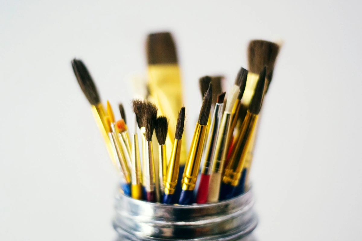 Outils de peintre décorateur, brosses et lames posés sur un établi