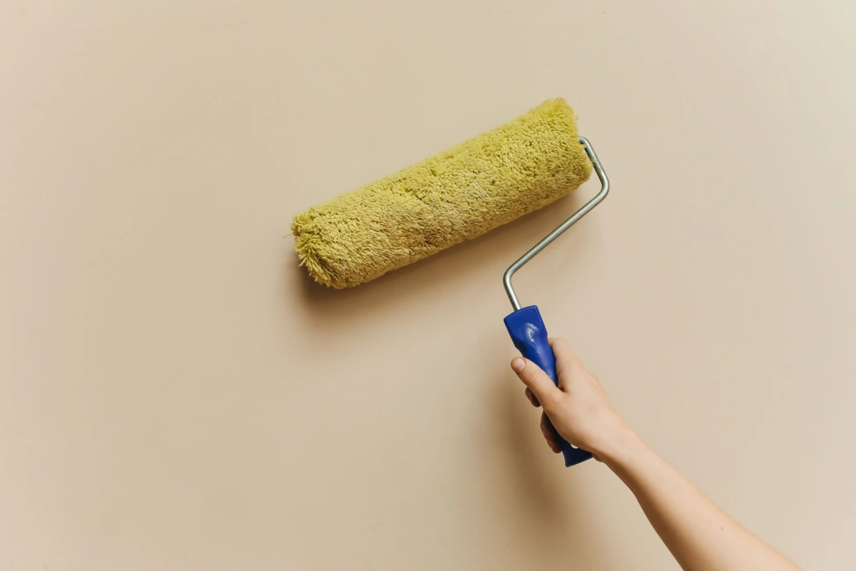 Application au rouleau d’une peinture claire sur un mur intérieur